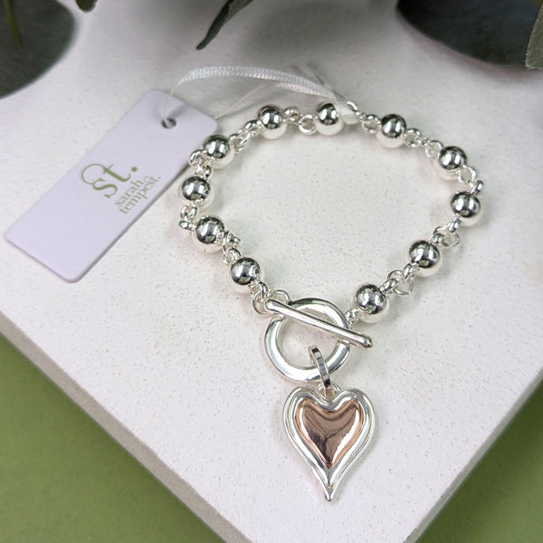 Multi tone heart charm beaded bracelet with t-bar clasp