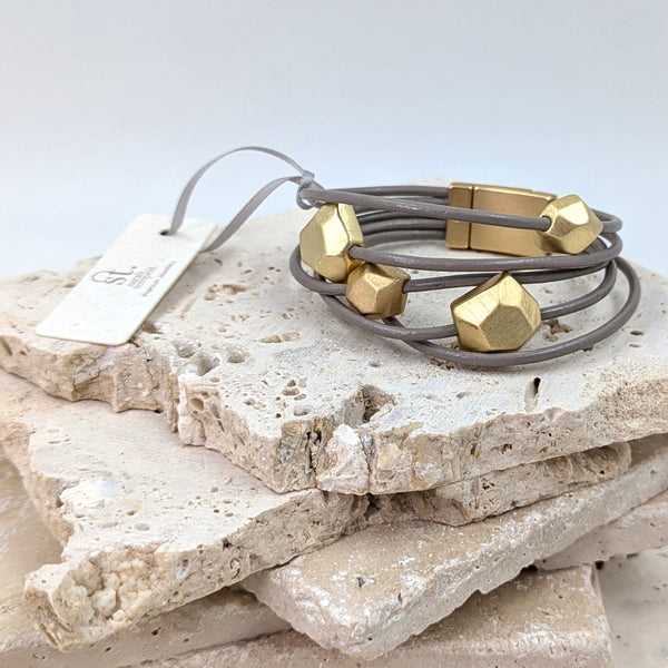 Multistrand leather bracelet with facetted stone like components and magnetic clasp