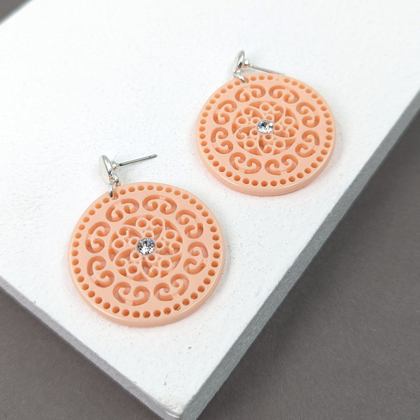 Post earrings w/ a stylish cut out design on resin disc