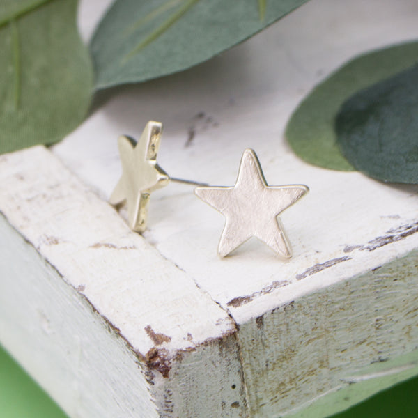 Worn gold star stud earrings