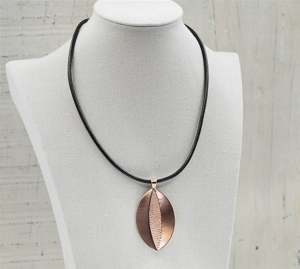 Oval pendant w/beaten detail on simple leather necklace