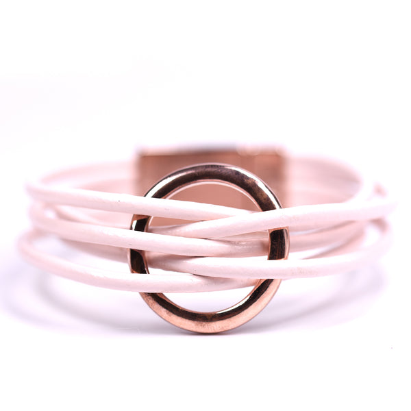 Pink leather cord bracelet woven through a rose gold ring