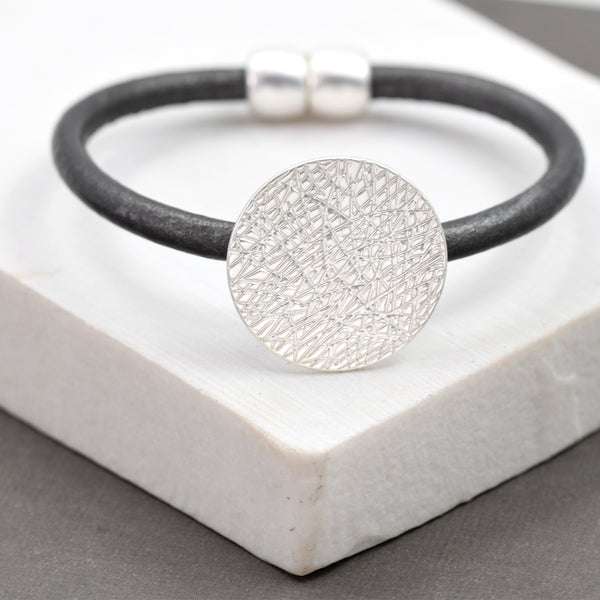 Single strand leather bracelet with scratched circle pendant